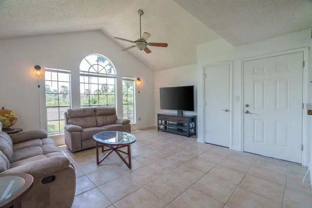 a living room with furniture a window and a flat screen tv