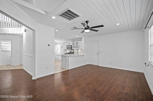 a view of a kitchen with a sink and wooden floor