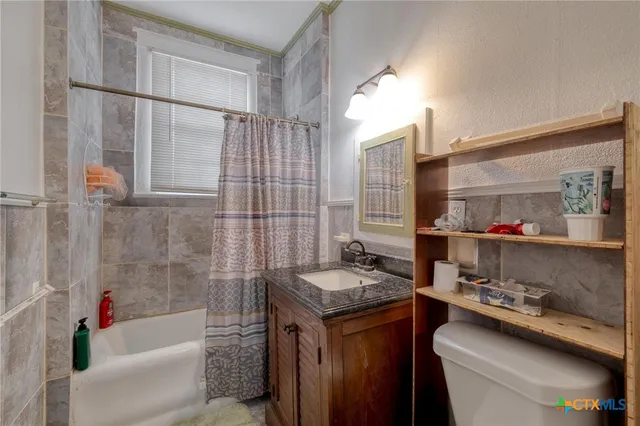 a bathroom with a granite countertop sink and a bathtub
