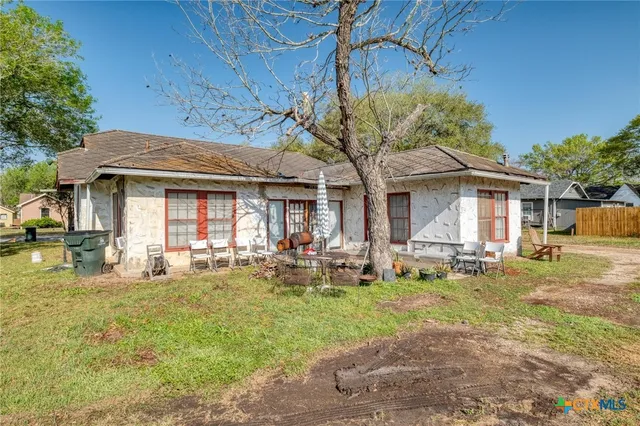 a front view of a house with swimming pool and chairs