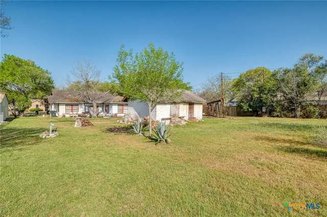 a backyard of a house with table and chairs