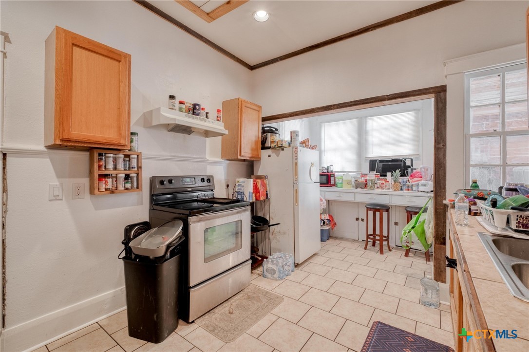 809 South Pecan Avenue Luling, TX 78648 - Photo 7 of 26 a kitchen with a refrigerator and a stove