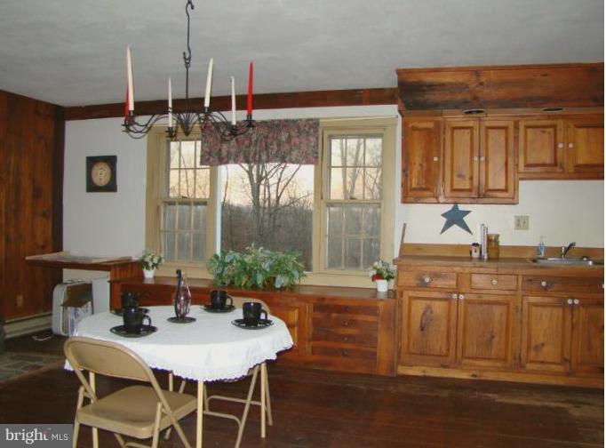 8200 Sixes Bridge Road Keymar, MD 21757 - Photo 22 of 30 a kitchen with a table chairs and white cabinets