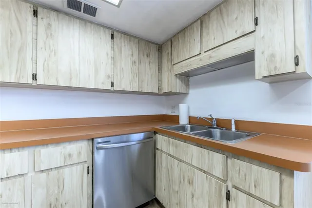 a kitchen with stainless steel appliances granite countertop white cabinets and a sink