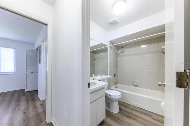a bathroom with a bathtub shower sink mirror and toilet