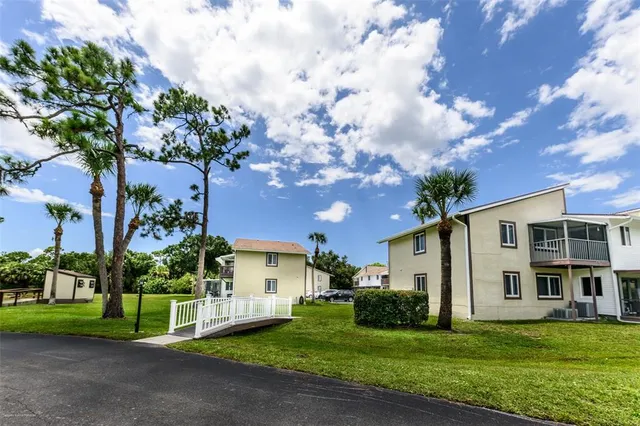 a view of a house with a big yard and large trees