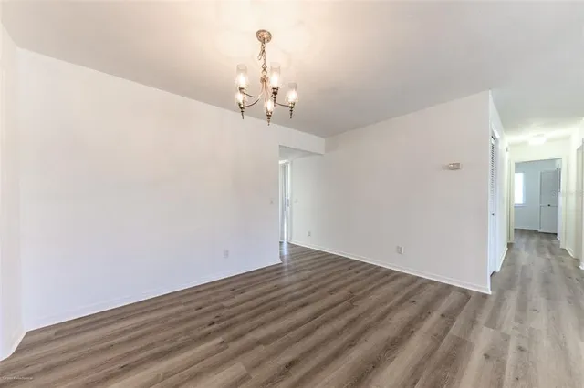 a view of a room with wooden floor and chandelier