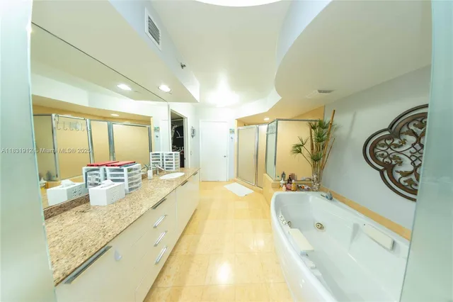 a spacious bathroom with a tub sink and mirror