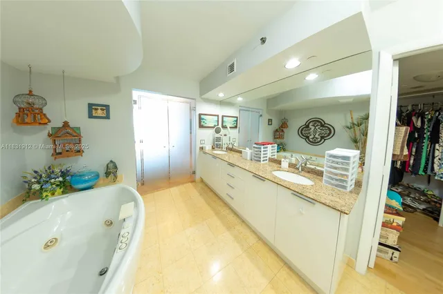 a spacious bathroom with a tub sink and mirror