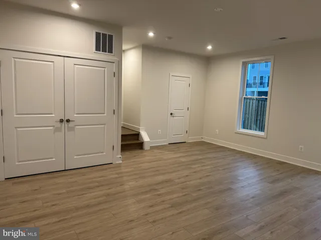 an empty room with wooden floor and cabinet