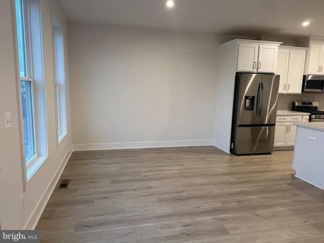 a view of a refrigerator in kitchen and wooden floor