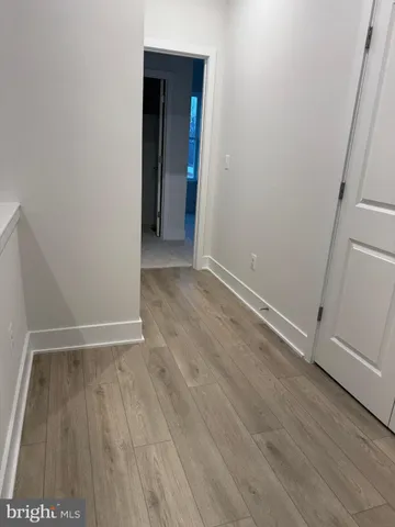 an empty room with wooden floor and entrance