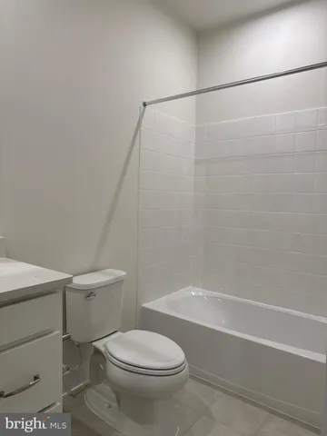 a white toilet sitting next to a bath tub