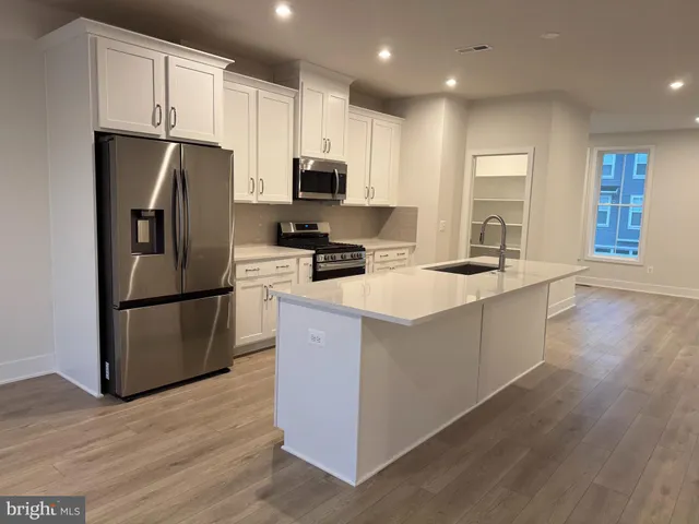 a kitchen with stainless steel appliances granite countertop a refrigerator a stove a sink and a microwave