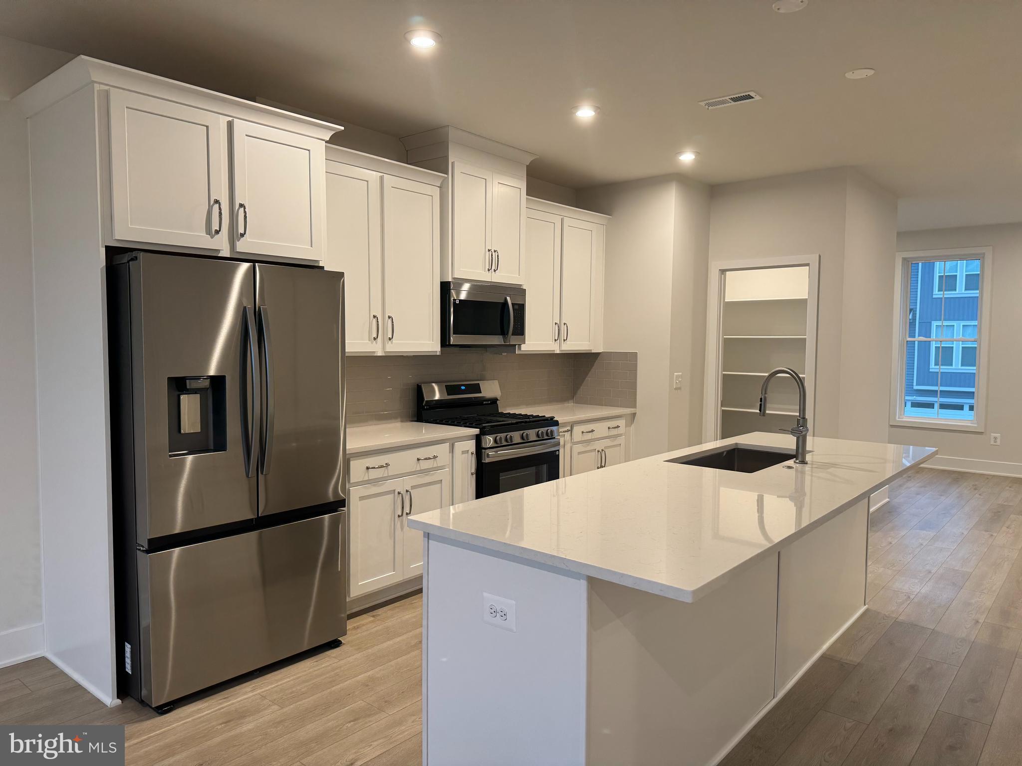 112 Galaxy Place Stephenson, VA 22656 - Photo 5 of 31 a kitchen with a refrigerator a microwave oven a sink and cabinets