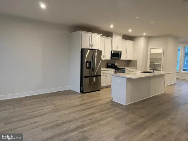 a kitchen with stainless steel appliances a refrigerator sink and cabinets
