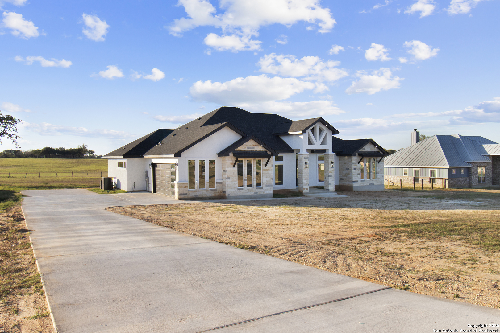 a front view of house with yard and ocean