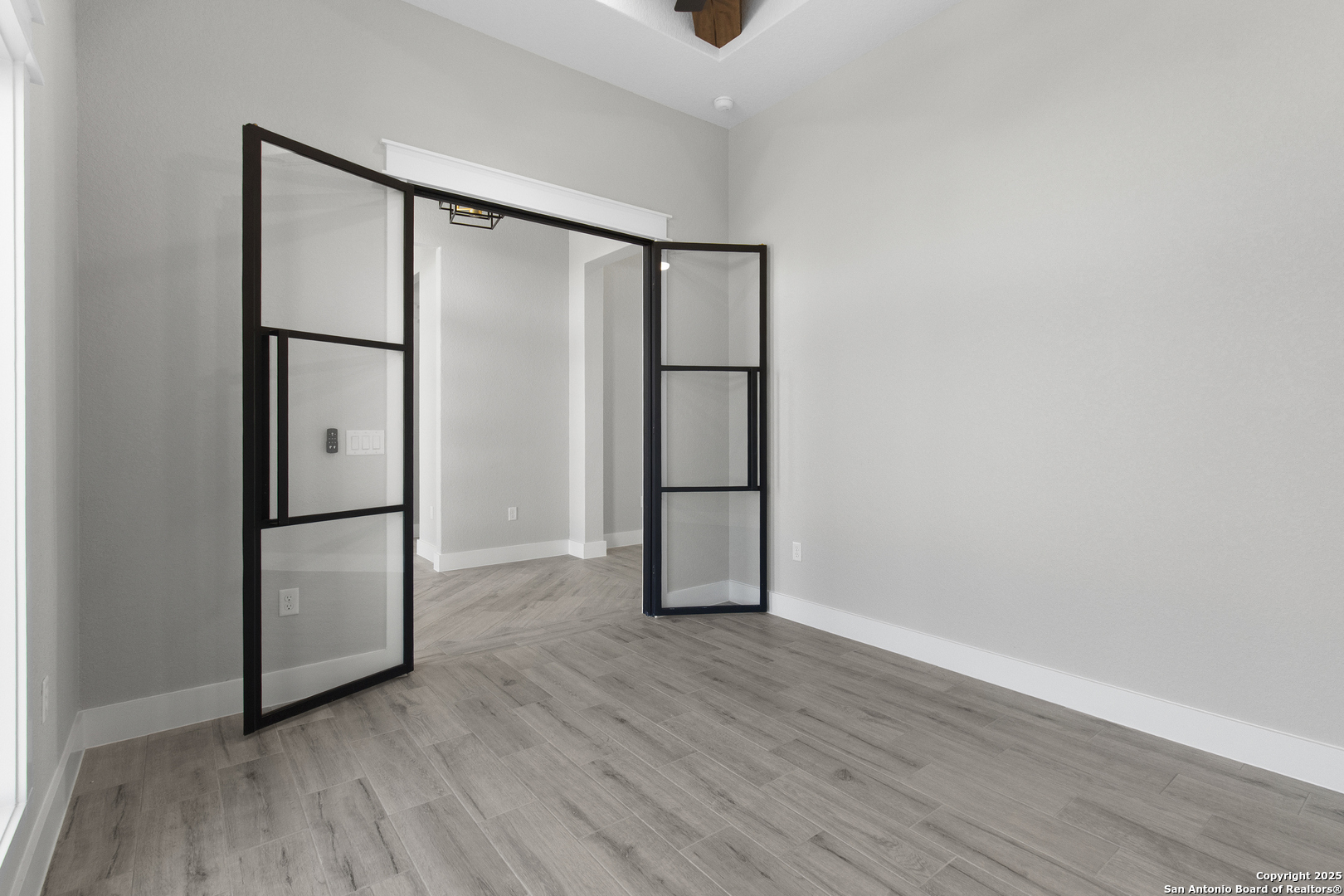 116 Western Way Adkins, TX 78101 - Photo 14 of 50 a view of an empty room with wooden floor and a window