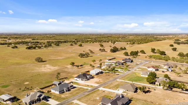 an aerial view of ocean and residential houses with outdoor space