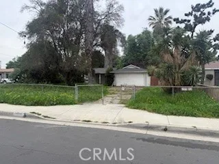 a front view of a house with a garden and a tree