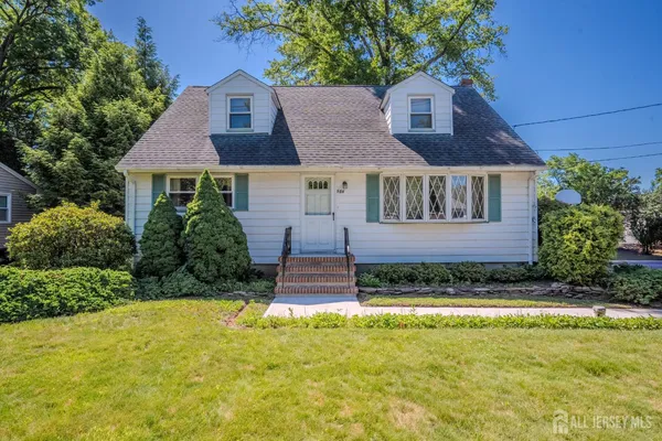a front view of a house with a yard and potted plants