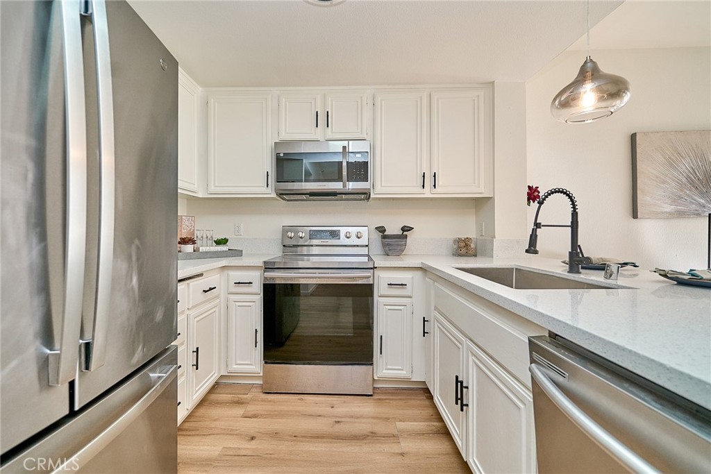 720 West 4th Street, Unit 305 Long Beach, CA 90802 - Photo 11 of 52 a kitchen with stainless steel appliances white cabinets a sink and a stove