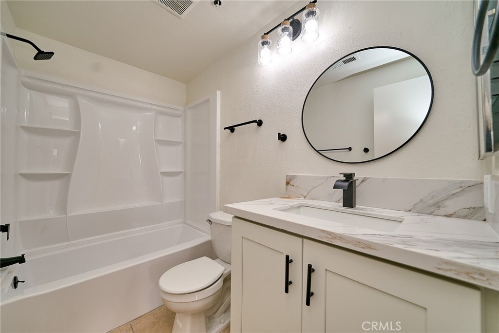 720 West 4th Street, Unit 305 Long Beach, CA 90802 - Photo 23 of 52 a bathroom with a granite countertop toilet a sink and a mirror