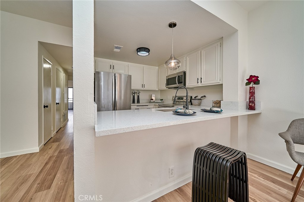 720 West 4th Street, Unit 305 Long Beach, CA 90802 - Photo 10 of 52 a kitchen with granite countertop a refrigerator and a sink