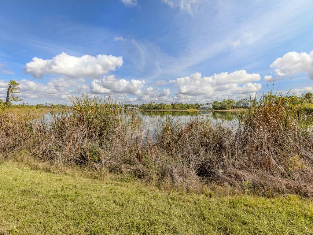 9008 Falcon Court Venice, FL 34293 - Photo 19 of 26 a view of a lake with a yard