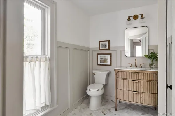 a bathroom with a toilet a sink and a window