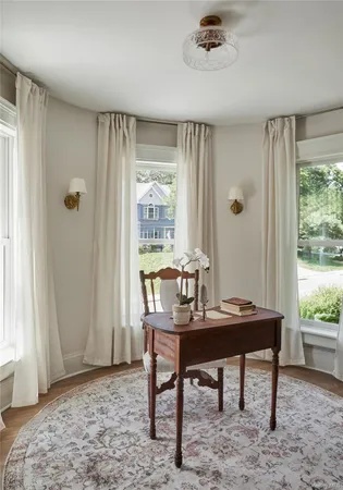 a view of a workspace with furniture and a window