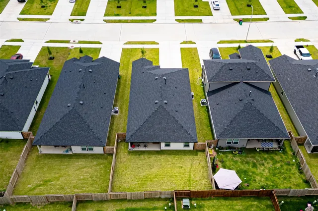an aerial view of residential houses with yard