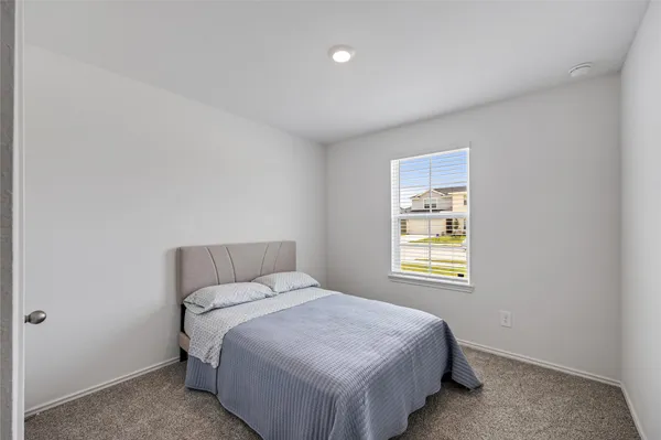 a bed sitting in a bedroom next to a window