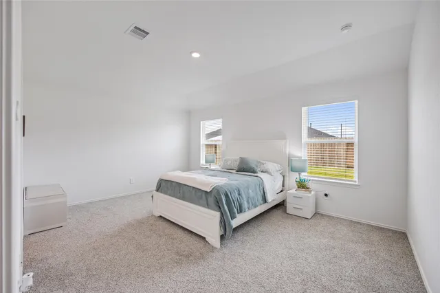 a spacious bedroom with a bed and a window