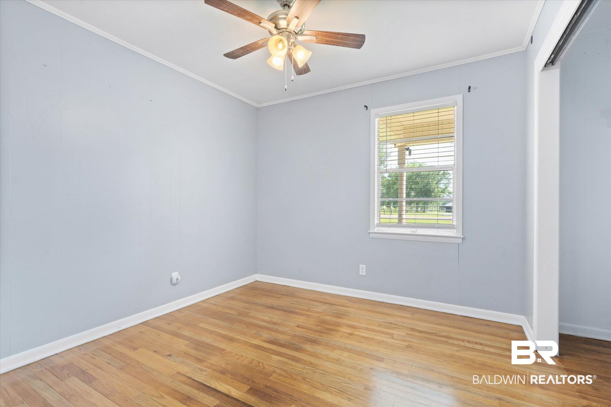 427 Upper Ferry Road Leroy, AL 36548 - Photo 8 of 37 Unfurnished room with light wood-style flooring, baseboards, crown molding, and a ceiling fan