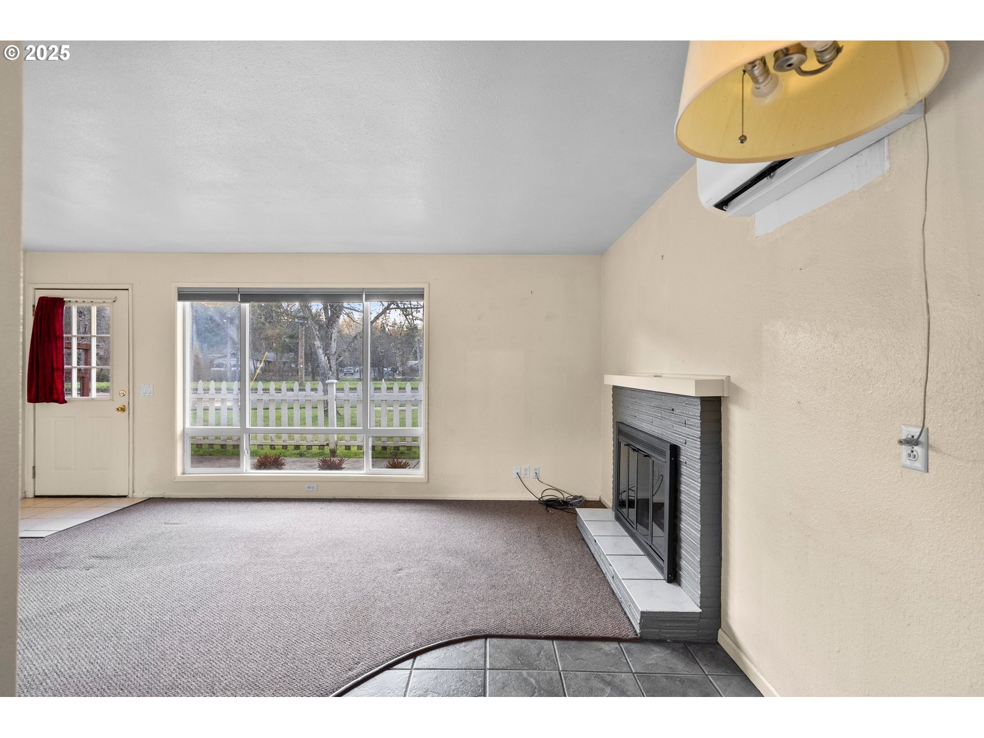 3875 East Amazon Drive Eugene, OR 97405 - Photo 13 of 33 a view of an empty room with a fireplace and a window