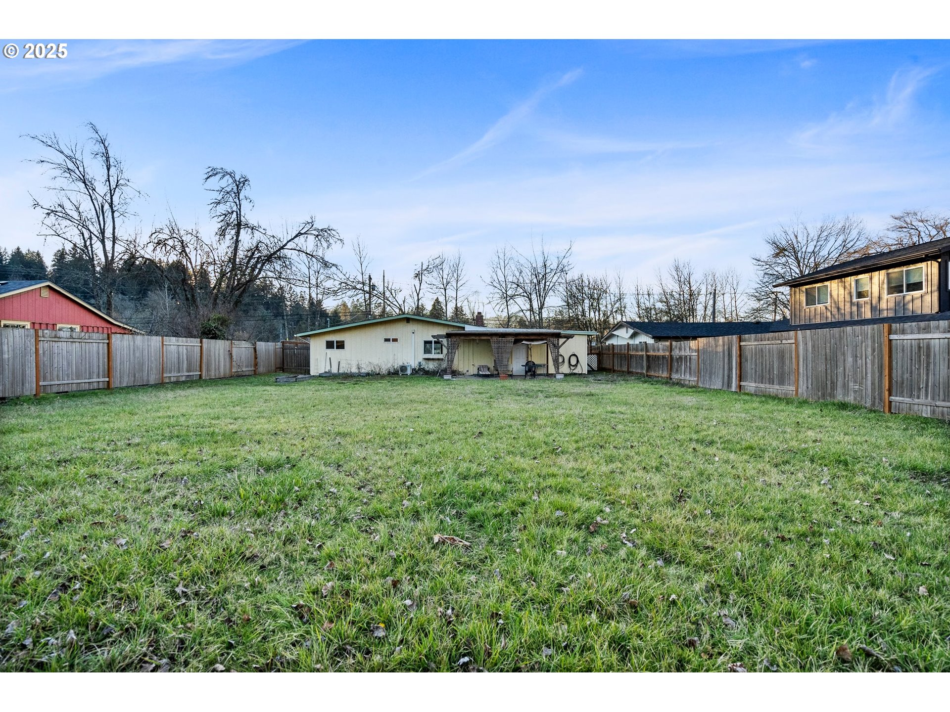 3875 East Amazon Drive Eugene, OR 97405 - Photo 30 of 33 a view of a backyard with table and chairs and wooden fence