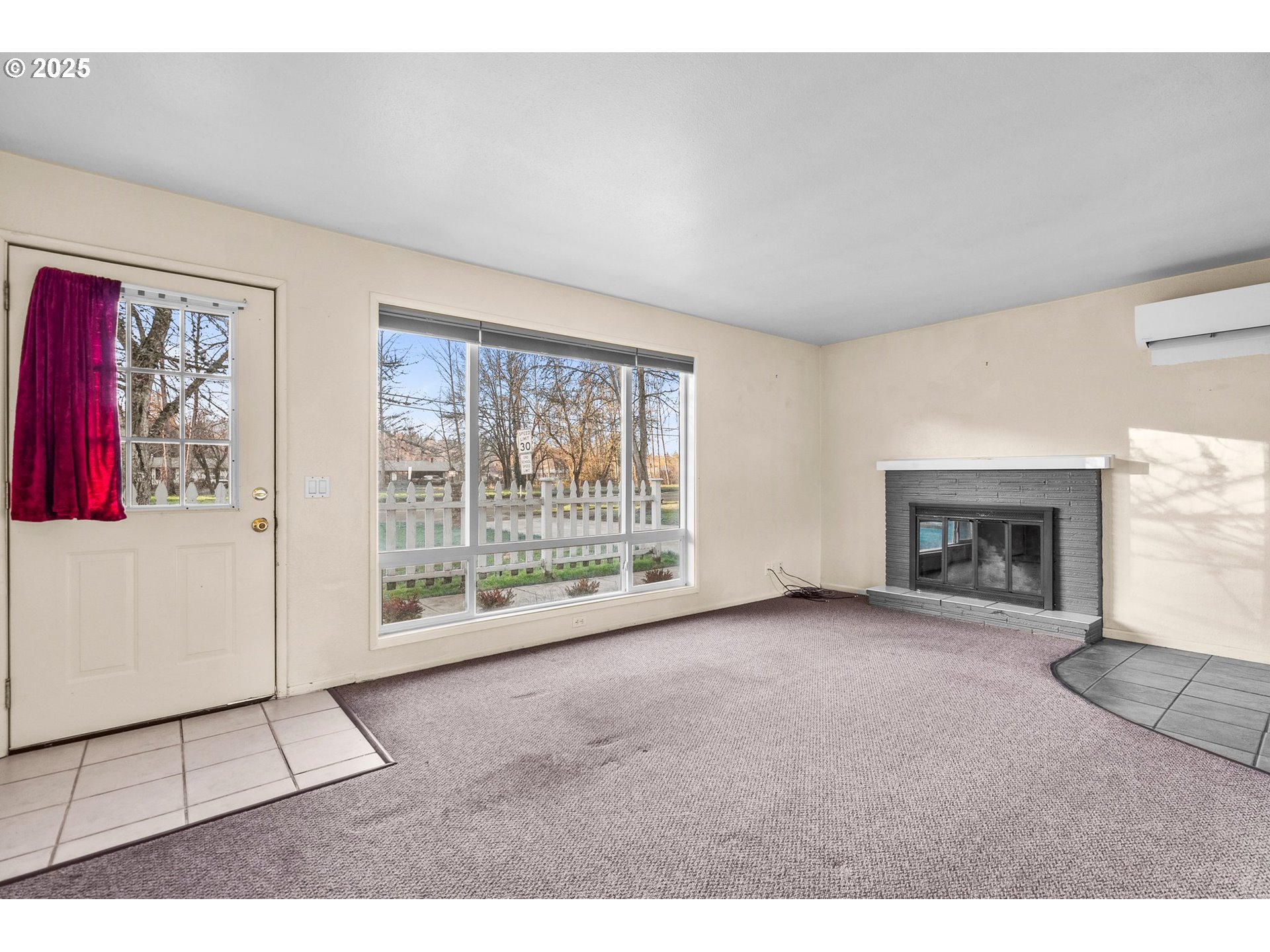 3875 East Amazon Drive Eugene, OR 97405 - Photo 10 of 33 a view of an empty room with a fireplace and a large window