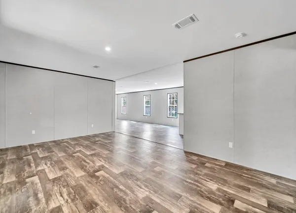 a view of empty room with wooden floor