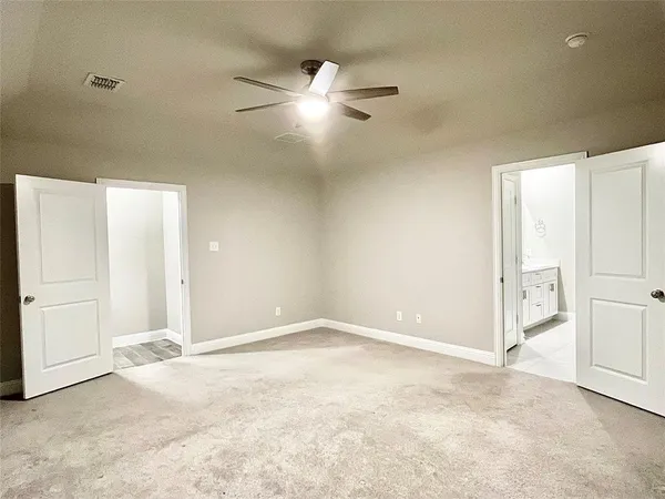 an empty room with a ceiling fan and a window