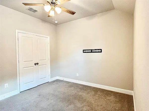 an empty room with a window and a fan