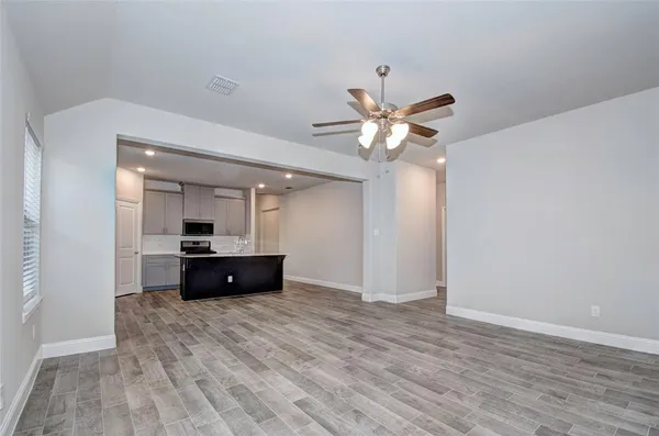 a living room with furniture and a ceiling fan