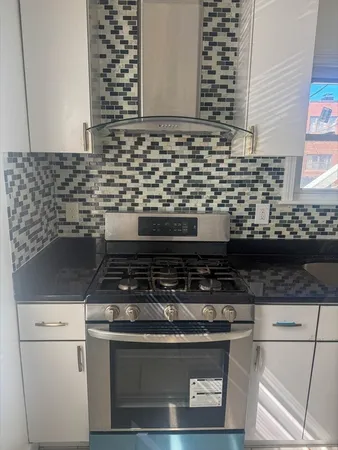 a stove top oven sitting inside of a kitchen