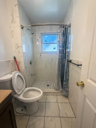 a white toilet sitting next to a shower curtain