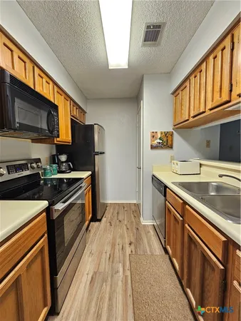 a kitchen with stainless steel appliances granite countertop a stove a sink and a microwave