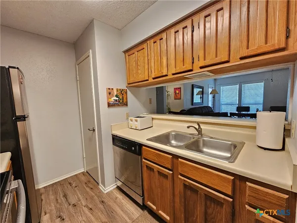 a kitchen with stainless steel appliances granite countertop a sink and a refrigerator
