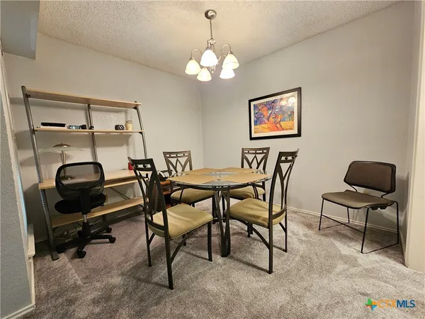 a view of a dining room with furniture and a chandelier