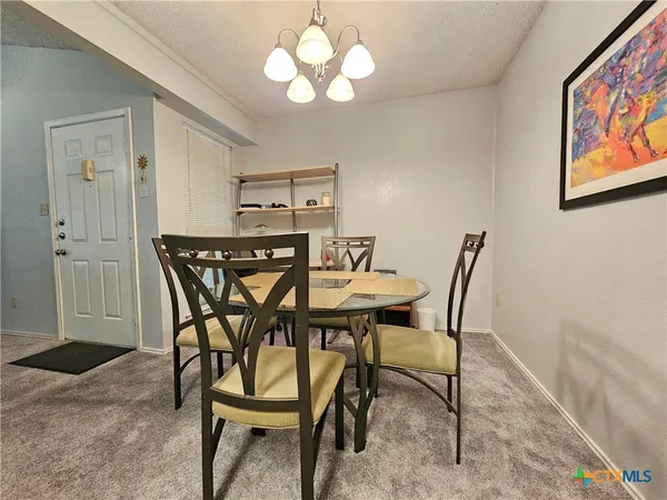 a view of a dining room with furniture and chandelier