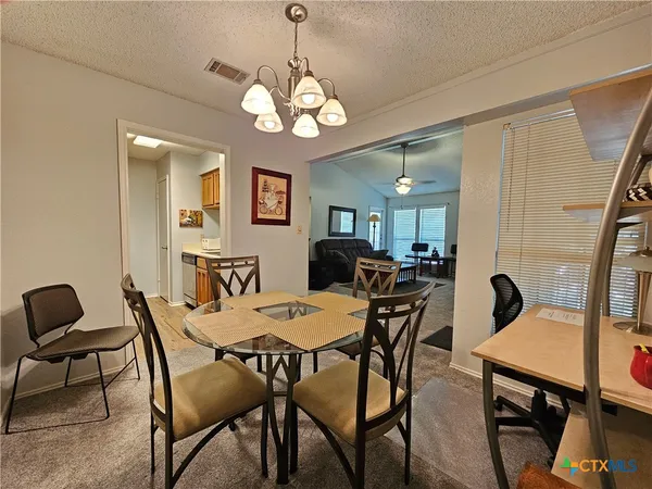 a view of a dining room with furniture and chandelier