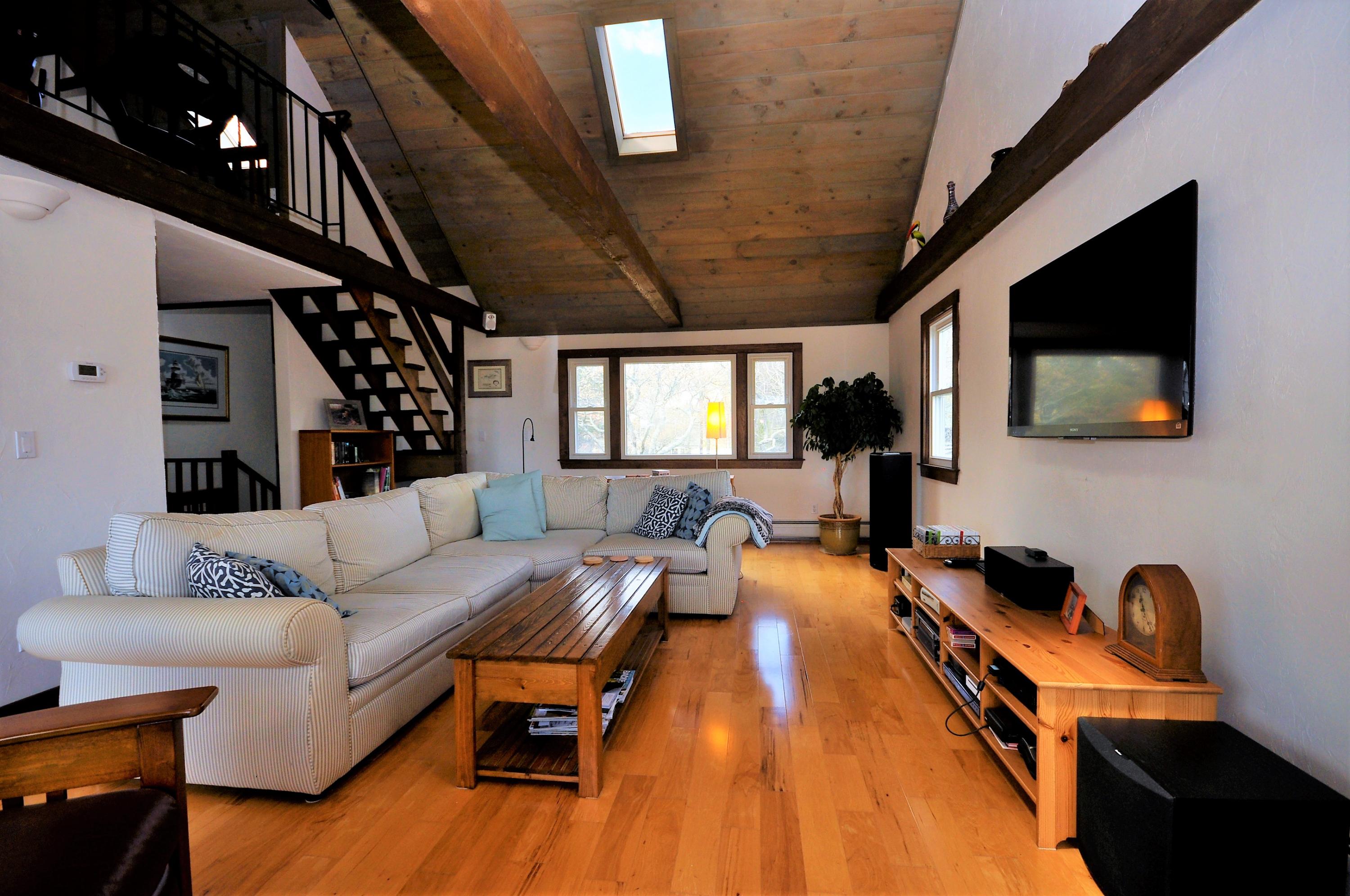 8 McGrath Road Sagamore Beach, MA 02562 - Photo 5 of 25 a living room with furniture a flat screen tv and kitchen view